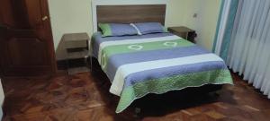 1 dormitorio con 1 cama con colcha colorida en GOLDEN DREAMS en Callampaya