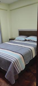 a bedroom with a bed with a striped blanket on it at GOLDEN DREAMS in Callampaya