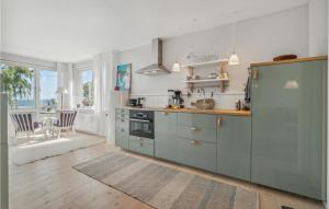 a kitchen with blue cabinets and a counter top at Amazing Apartment In Svaneke With Kitchen in Svaneke