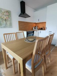 uma mesa de jantar em madeira com cadeiras e uma cozinha em Ferienwohnung Harzlich em Hahnenklee-Bockswiese