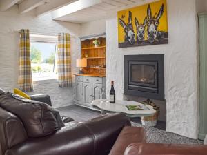 a living room with a couch and a fireplace at Yr Ysgubor - U45300 in Carmarthen