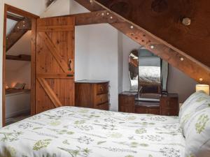a bedroom with a bed and a wooden door at Yr Ysgubor - U45300 in Carmarthen