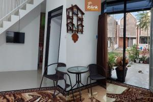 a table and chairs in a room with a window at IbLink Homestay Family Homestay di Dau Malang in Malang