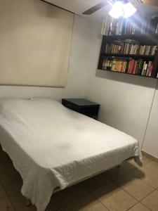 a bedroom with a white bed and a book shelf at PH Cosmopolitan Towers Business Trip Flat with 2 Rooms fitting up to 6 people in Panama City