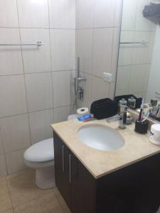 a bathroom with a sink and a toilet and a mirror at PH Cosmopolitan Towers Business Trip Flat with 2 Rooms fitting up to 6 people in Panama City