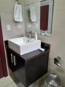 La salle de bains est pourvue d'un lavabo blanc et d'un miroir. dans l'établissement Casafrancesbqte, à Boquete