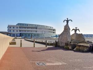 a statue on the beach with a building in the background at Blue Sands in Morecambe