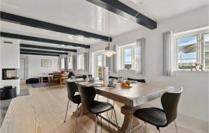 uma sala de jantar e sala de estar com mesa e cadeiras em 3 Bedroom Nice Home In Fan em Sønderho