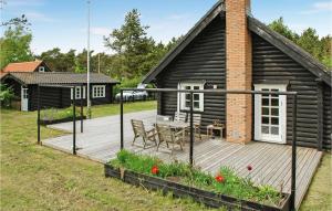 uma casa com um deque de madeira com uma mesa e cadeiras em Gorgeous Home In Knebel With Wifi em Skødshoved Strand