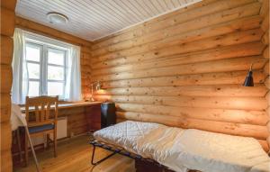 1 dormitorio con pared de madera, cama y escritorio en Gorgeous Home In Knebel With Wifi, en Skødshoved Strand