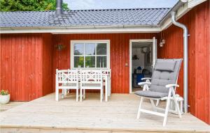 ein rotes Haus mit einer Terrasse mit Stühlen und einem Tisch in der Unterkunft Cozy Home In Ebeltoft With Wifi in Ebeltoft