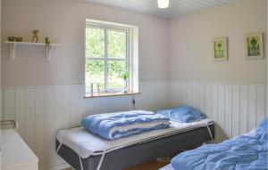 エーベルトフトにあるBeautiful Home In Ebeltoft With 2 Bedrooms And Wifiのベッド2台と窓が備わる客室です。
