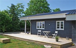 una pequeña casa azul con terraza de madera en Lovely Home In Hornslet With Kitchen en Hornslet