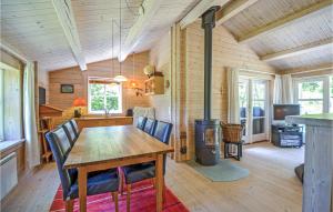 una sala da pranzo con tavolo e stufa a legna di Nice Home In Ebeltoft With Kitchen a Ebeltoft