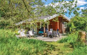 ein Haus mit einer Terrasse mit Stühlen und einem Tisch in der Unterkunft Nice Home In Ebeltoft With Kitchen in Ebeltoft
