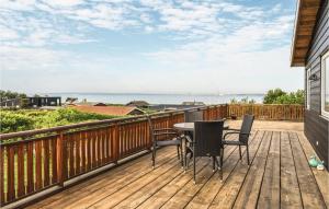 eine Terrasse mit einem Tisch, Stühlen und Meerblick in der Unterkunft Awesome Home In Knebel With Wifi in Knebel