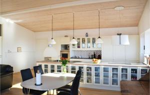 eine Küche mit weißen Schränken sowie einem Tisch und Stühlen in der Unterkunft Awesome Home In Knebel With Wifi in Knebel