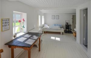a white room with a bed and a table at Beautiful Home In Anholt With Kitchen in Anholt