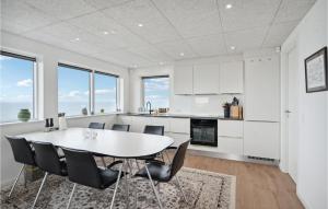 a white kitchen with a table and chairs at Amazing Home In Esbjerg V With Wifi And 2 Bedrooms in Esbjerg