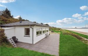 a small white building with a patio next to a body of water at Stunning Home In Esbjerg V With Kitchen in Esbjerg