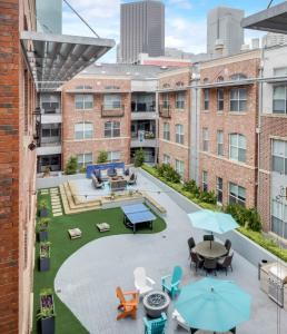 an outdoor patio with tables and chairs on a building at Loft Style 2BR Apt I Dallas City Center I Pool I Gym I Workspace I Pets in Dallas