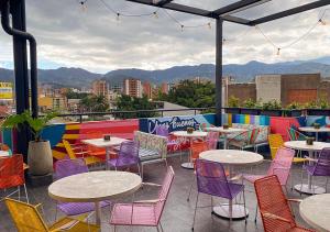 a patio with tables and chairs and mountains in the background at Mythical Hotel - Boutique in Medellín