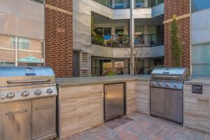 a outdoor kitchen with two stoves in front of a building at Loft Style 2BR Apt I Dallas City Center I Pool I Gym I Workspace I Pets in Dallas