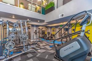 a gym with treadmills and elliptical machines at Loft Style 2BR Apt I Dallas City Center I Pool I Gym I Workspace I Pets in Dallas