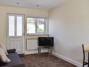 a living room with a flat screen tv next to a door at Mutley Hall in Eastergate
