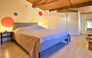 een slaapkamer met een groot bed en een houten vloer bij Stunning Home In Laudun-lardoise With Wifi in Laudun