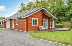 una pequeña casa de ladrillo rojo con porche en 3 Bedroom Amazing Home In Juelsminde, en Sønderby