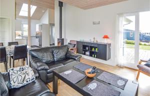 sala de estar con sofá de cuero y mesa en 3 Bedroom Amazing Home In Juelsminde, en Sønderby