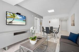 a living room with a tv on a wall at Fortune House Hotel Suites in Miami