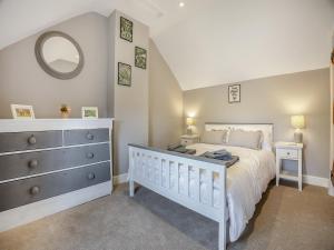 um quarto com uma cama, uma cómoda e um espelho em Huntspill Cottage em Holbeach