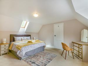 a bedroom with a bed and a table and a chair at The Stirrup Cottage in Blyborough