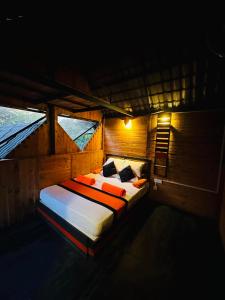 a bedroom with a bed in a room with windows at hornbill river camp udawalwa in Udawalawe