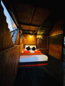 a bedroom with a bed in a wooden room at hornbill river camp udawalwa in Udawalawe