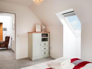 a bedroom with a white cabinet and a window at Palace View - Uk40569 in Falkland