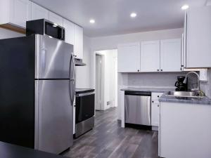 a kitchen with white cabinets and a stainless steel refrigerator at New Downtown on BSU Campus 3 Beds Fully Remodeled in Boise