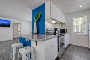 eine Küche mit weißen Schränken und einer Wand mit blauen Akzenten in der Unterkunft New Downtown on Bsu Campus 3 Beds on Boise Ave in Boise