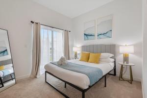 Un dormitorio con una cama con almohadas amarillas y una ventana en New Sunset Edge House Renton, en Renton