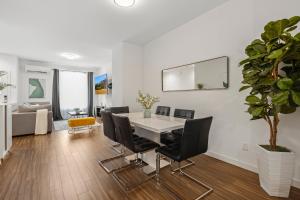 a dining room with a white table and black chairs at New Sunset Edge House Renton in Renton