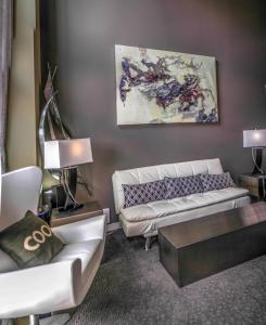 a living room with two white couches and a painting at Penthouse Suite Downtown, Top Floor 4 Beds, 2Baths in Seattle