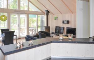 ØksenmølleにあるGorgeous Home In Ebeltoft With Kitchenのカウンター、椅子、窓が備わる客室です。