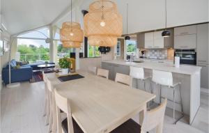 エーベルトフトにあるAwesome Home In Ebeltoft With 3 Bedrooms, Sauna And Wifiのキッチン、ダイニングルーム(木製のテーブルと椅子付)