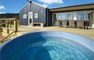 a large blue swimming pool in front of a house at Cozy Home In Ebeltoft With Wifi in Ebeltoft