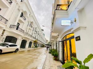 a street with white buildings and a white car at NẮNG Homestel Tây Ninh in Tây Ninh