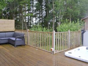 a wooden deck with a bench and a bath tub at Little Fawn in Otterburn