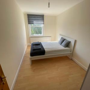 a small bedroom with a bed and a window at Entire 3 BR Home - Minutes to Emirates Stadium! in London