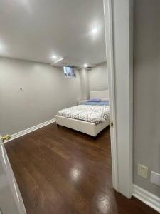 ein Schlafzimmer mit einem Bett in der Ecke eines Zimmers in der Unterkunft Guest Suite in Oakville in Oakville